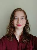 Woman in red shirt smiles into camera.